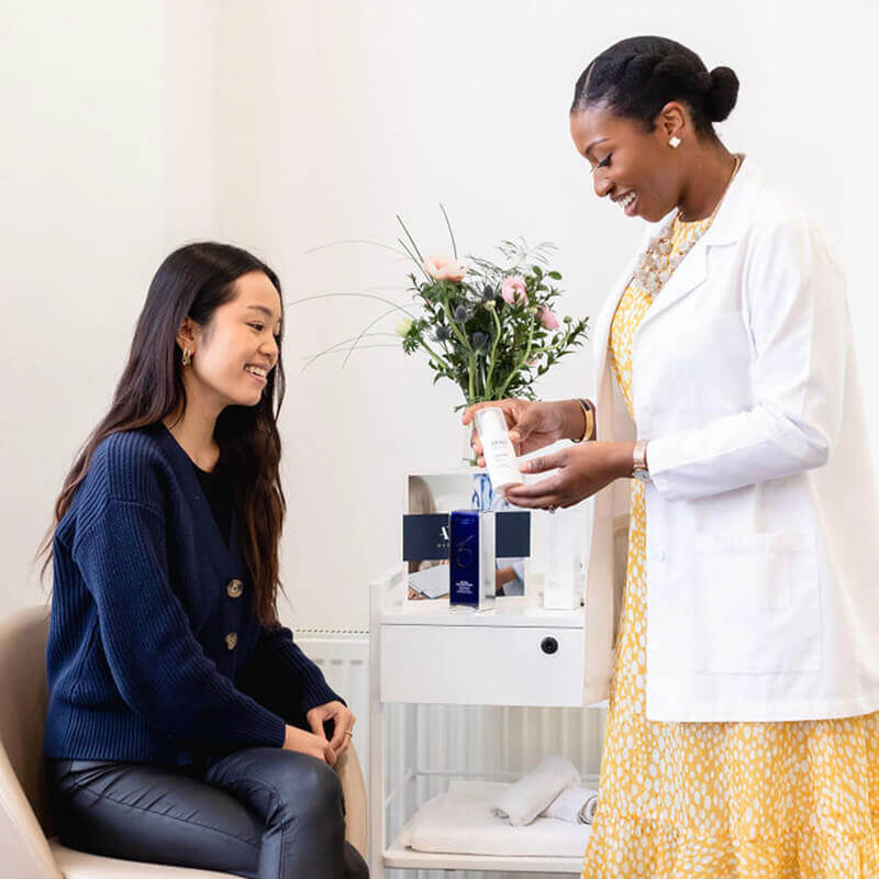 Dr Ifeoma Ejikeme discus with female patient about Skin Tightening treatment